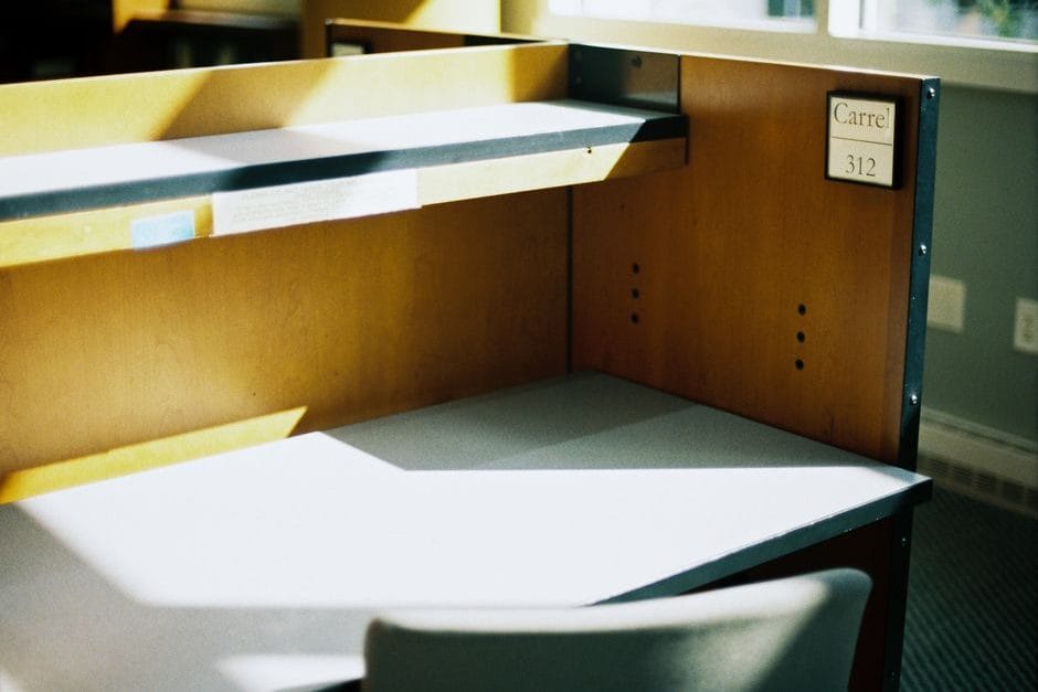 Ruhiger, fast leerer Büroarbeitsplatz mit Sommerlicht durch das Fenster